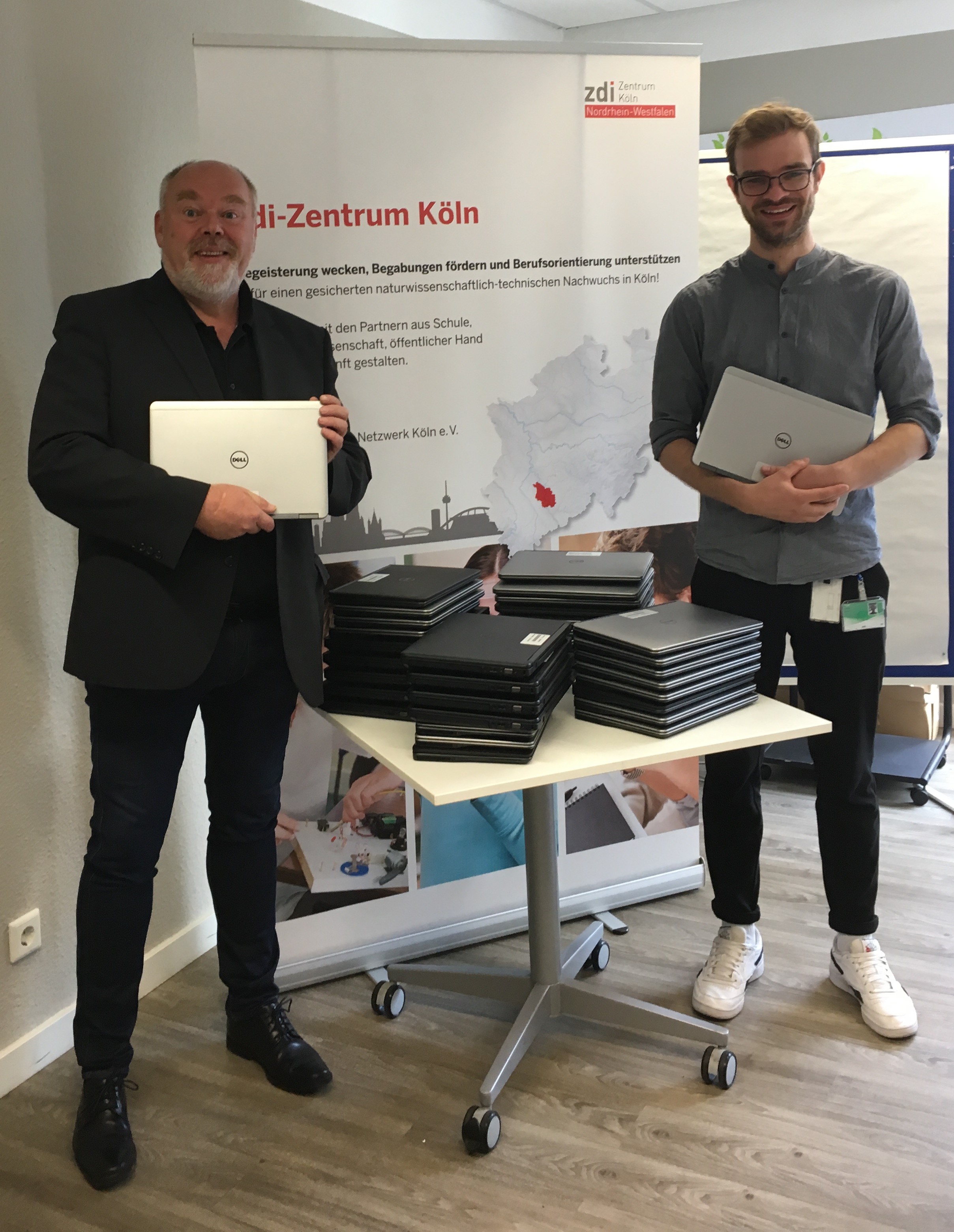 Image Foto — Kai Sterzenbach von Lernende Region – Netzwerk Köln (links) erhält die Laptops von Jannik Ludwig, IT-Mitarbeiter bei ExxonMobil